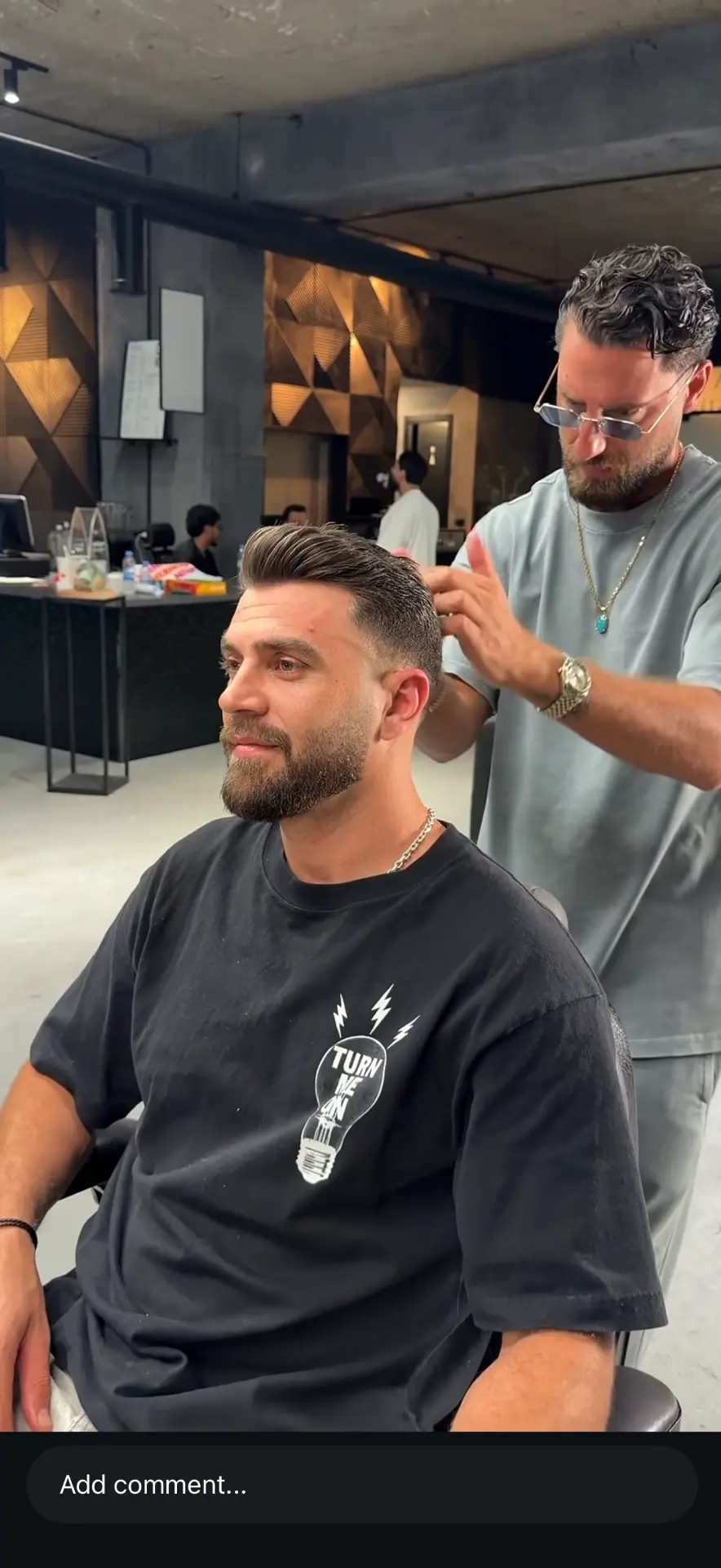Yoyo and Kreik barber finishing a client's haircut in the shop