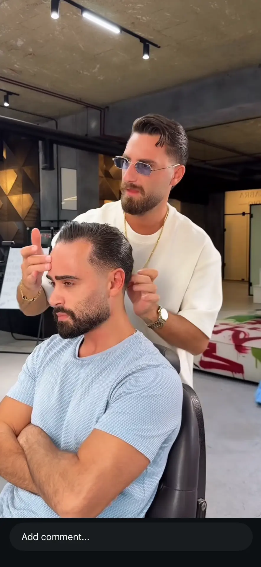 Yoyo and Kreik barber styling a client's hair in the shop
